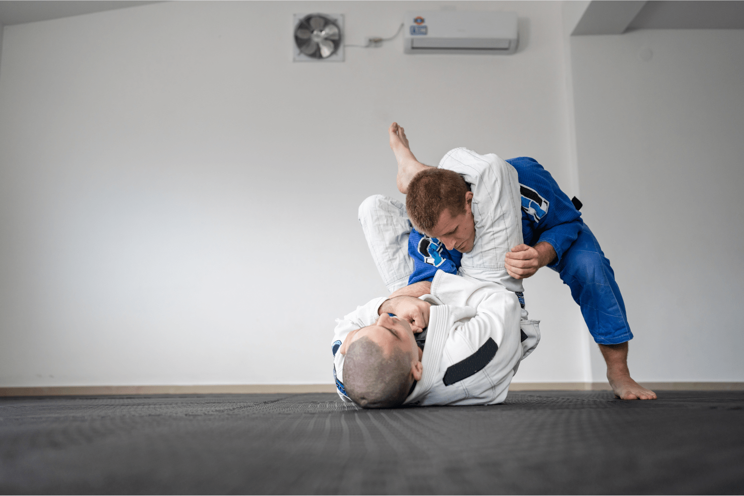 Practicantes ejecutando una técnica de triángulo de Brazilian Jiu-Jitsu