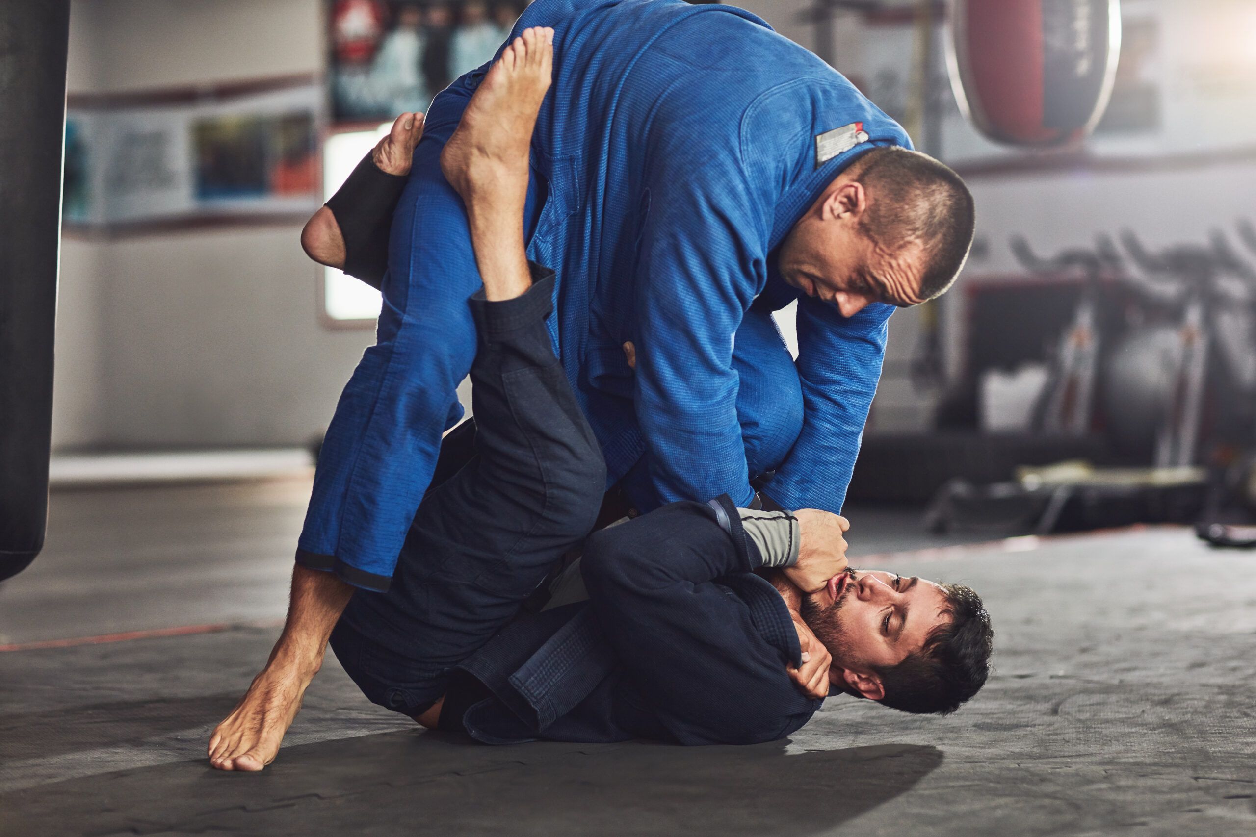 Dos practicantes entrenando Brazilian Jiu-Jitsu sobre el tatami